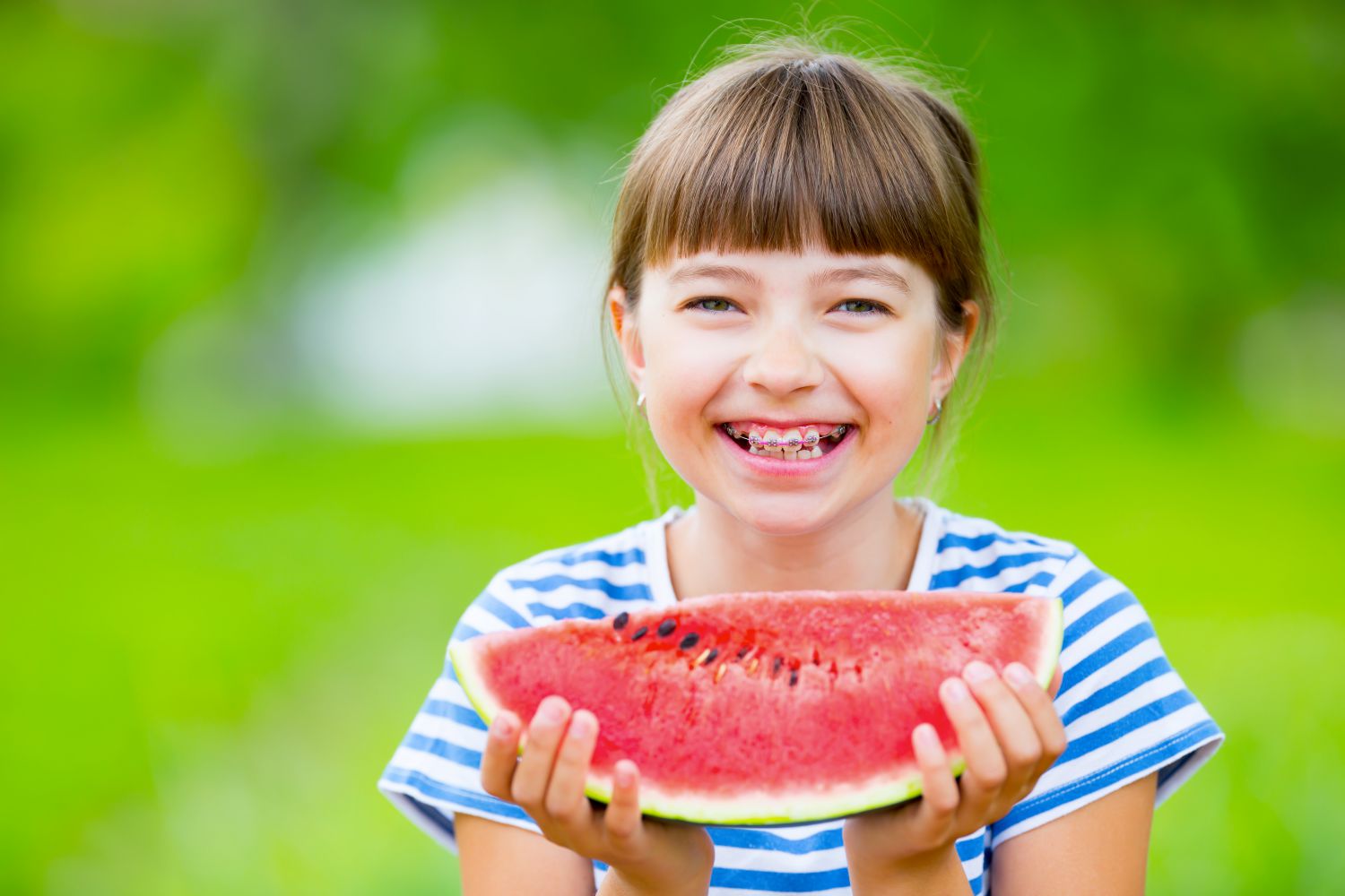 Child with braces eating watermelon in Spokane, WA